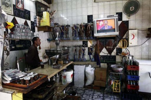 A worker at a coffee shop watches on TV as Egyptian President Mohamed Morsi takes the oath of office in Cairo on June 30. Morsi began his first full day in office on Sunday with his powers circumscribed by the military as he tries to pick a new cabinet to carry out his campaign pledges