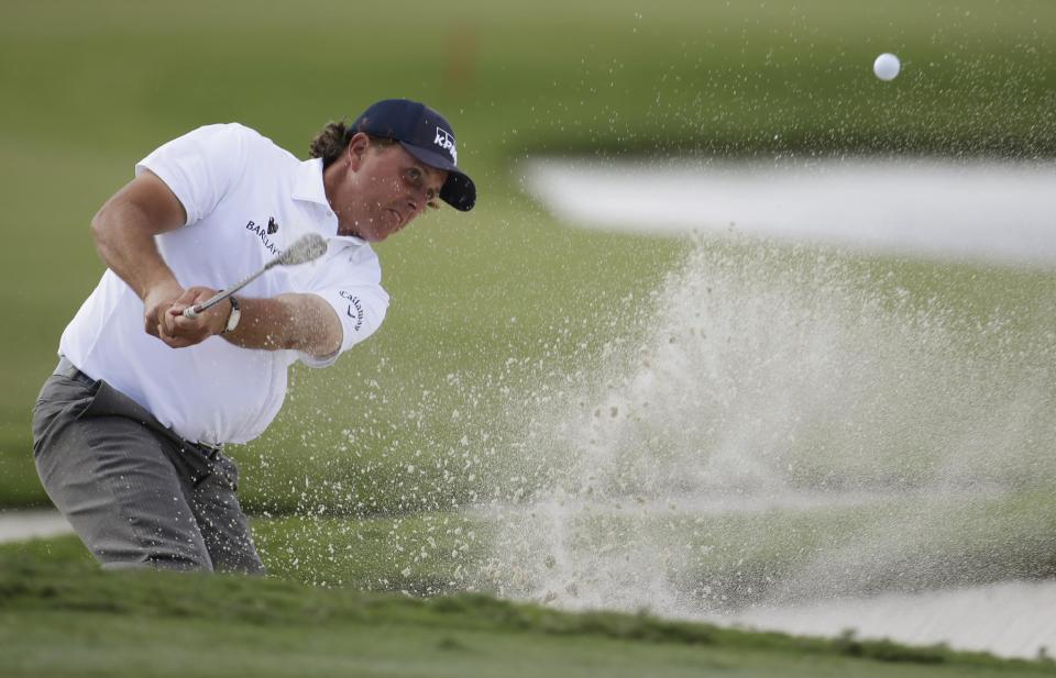 Phil Mickelson hits from a bunker on the ninth hole during the second round of the Cadillac Championship golf tournament, Friday, March 7, 2014, in Doral, Fla. (AP Photo/Lynne Sladky)