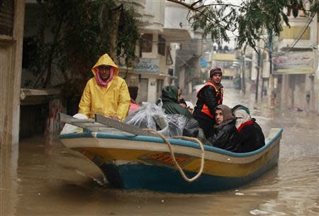 Members of Palestinian civil defense operate a boat as they evacuate people after their houses were flooded with rainwater on a stormy day in the northern Gaza Strip December 14, 2013. REUTERS/Mohammed Salem