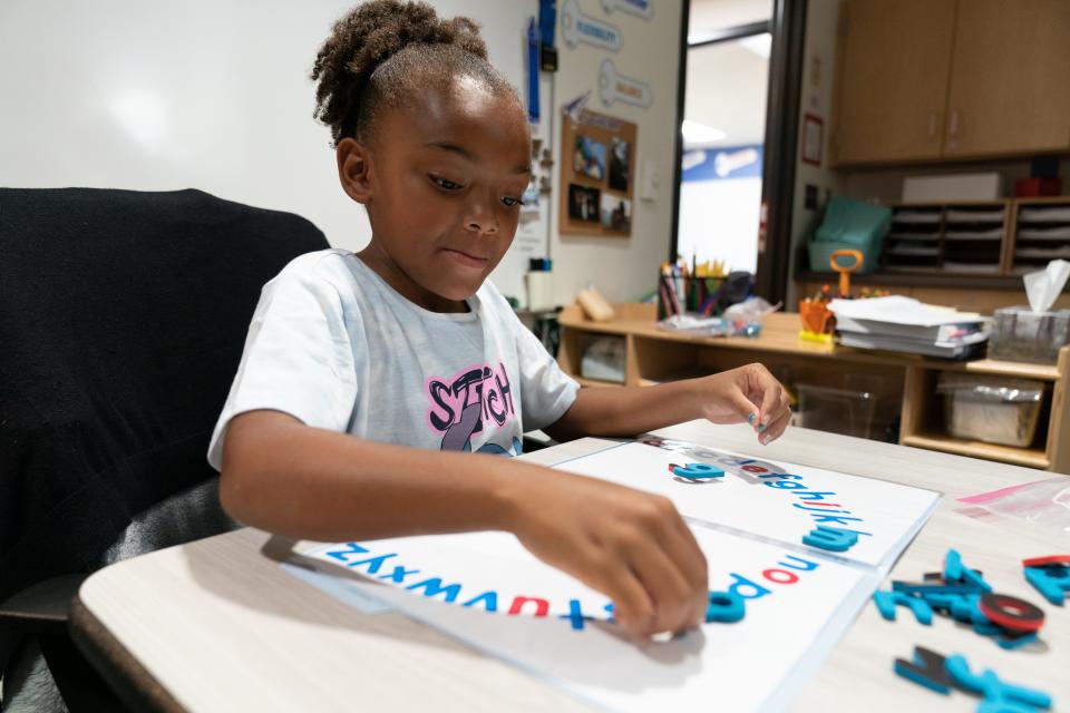 Journee Freeman, a first-grader at Berryton Elementary, places foam letters on an alphabet arc Friday morning. Reading teachers use the tactile models to help connect students' visual learning of letters to other senses, such as touch.