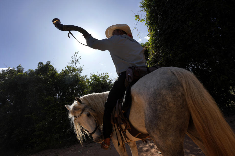 Un hombre a caballo durante un desfile por la tradición religiosa "Fiesta del Divino Espíritu Santo", en Pirenópolis, en el estado de Goias, Brasil, el sábado 28 de mayo de 2022. (AP Foto/Eraldo Peres)