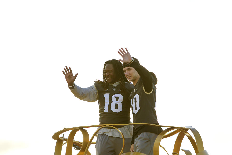 Central Florida football players Shaquem Griffin, left, and McKenzie Milton wave to fans during the a parade at Walt Disney World in the Magic Kingdom on Sunday, Jan. 7, 2018, in Orlando, Fla. (Jacob Langston/Orlando Sentinel via AP)