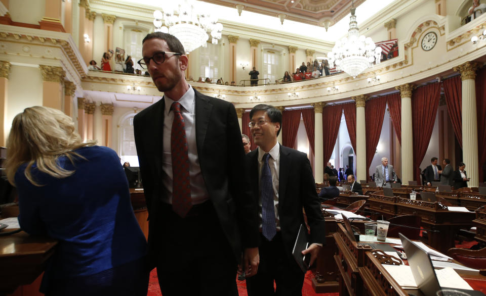 State Sen. Richard Pan, D-Sacramento, center, and other members of the Senate leave the Senate Chambers as opponents of Pan's recently passed legislation, SB276, to tighten the rules on giving exemptions for vaccinations demonstrate in the gallery at the Capitol in Sacramento, Calif., Monday, Sept. 9, 2019. Earlier the Assembly had approved SB714, a companion bill to SB276 with changes demanded by Gov Gavin Newsom as a condition of signing the controversial vaccine bill which was passed by the Legislature last week. SB714 still needs to be voted on by the Senate.(AP Photo/Rich Pedroncelli)