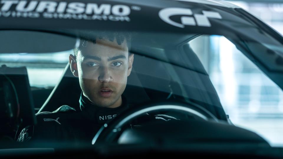 A man sits in the driver's seat of a race car