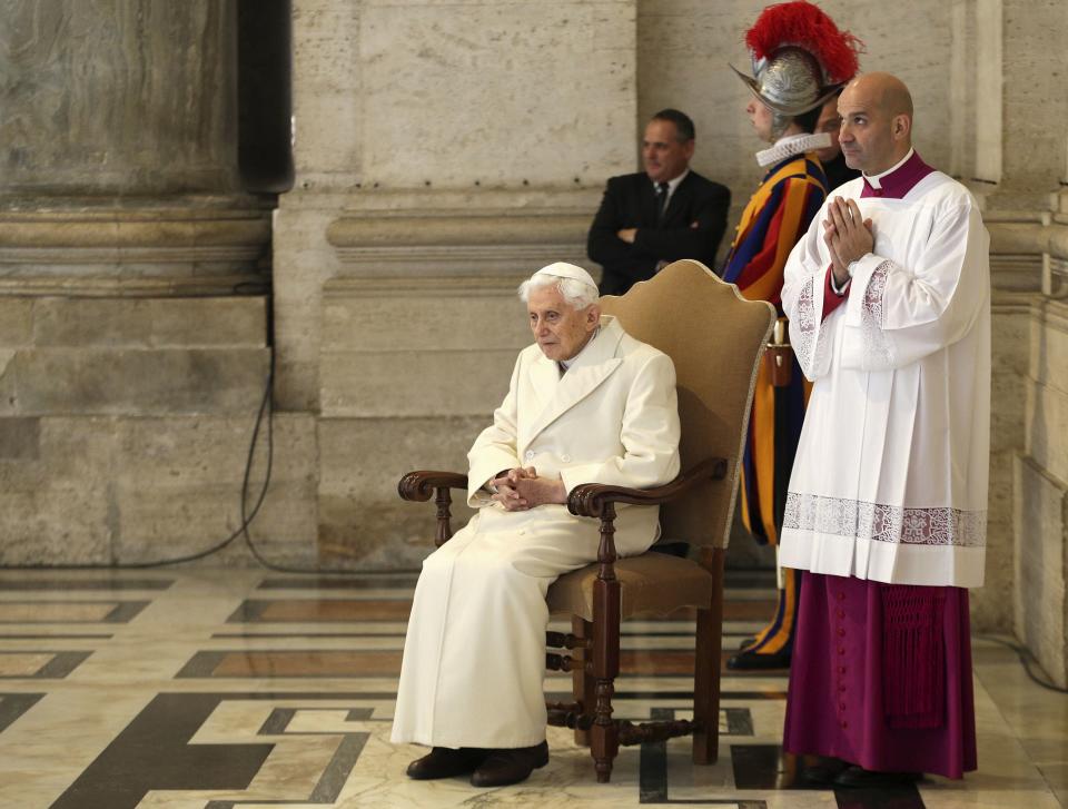 FILE PHOTO: Emeritus Pope Benedict XVI sits near the Holy Door as Pope Francis leads a mass to mark opening of the Catholic Holy Year, or Jubilee, in St. Peter's Square, at the Vatican