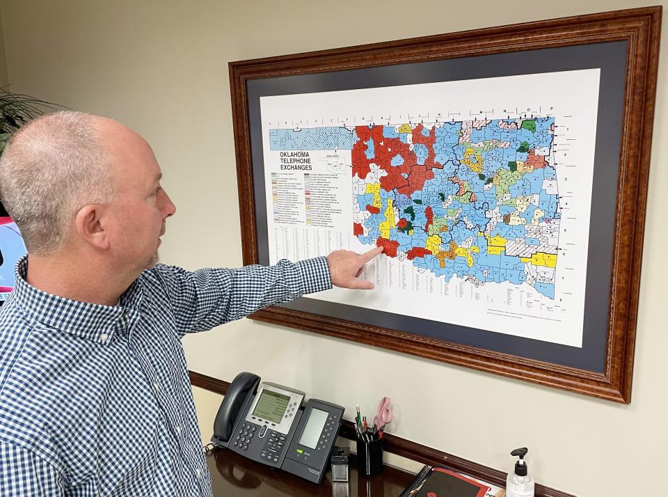 Blake Callaham, general manager of Pioneer Telephone Cooperative, points out the coop's telephone exchanges on a map at the headquarters in Kingfisher.