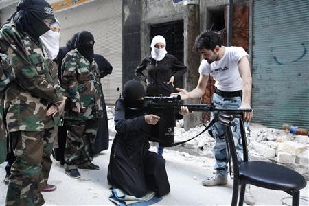 A female member of the "Mother Aisha" battalion receives instruction as she holds a rifle during military training in Aleppo's Salaheddine district, September 19, 2013. REUTERS/Loubna Mrie