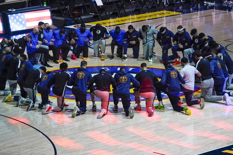 FILE - Members of the Denver Nuggets and the Dallas Mavericks lock arms and take a knee during the national anthem before an NBA basketball game in Denver, in this Thursday, Jan. 7, 2021, file photo. The NBA said Wednesday, Feb. 10, 2021, the national anthem will be played in arenas “in keeping with longstanding league policy” after Dallas Mavericks owner Mark Cuban revealed he had decided not to play it before his team's home games this season. (AP Photo/Jack Dempsey, File)