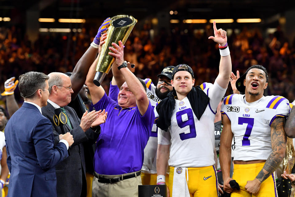 NEW ORLEANS, LOUISIANA - JANUARY 13: Head coach Ed Orgeron of the LSU Tigers raises the National Championship Trophy with Joe Burrow #9 and Grant Delpit #7 after the College Football Playoff National Championship game at the Mercedes Benz Superdome on January 13, 2020 in New Orleans, Louisiana. The LSU Tigers topped the Clemson Tigers, 42-25. (Photo by Alika Jenner/Getty Images)