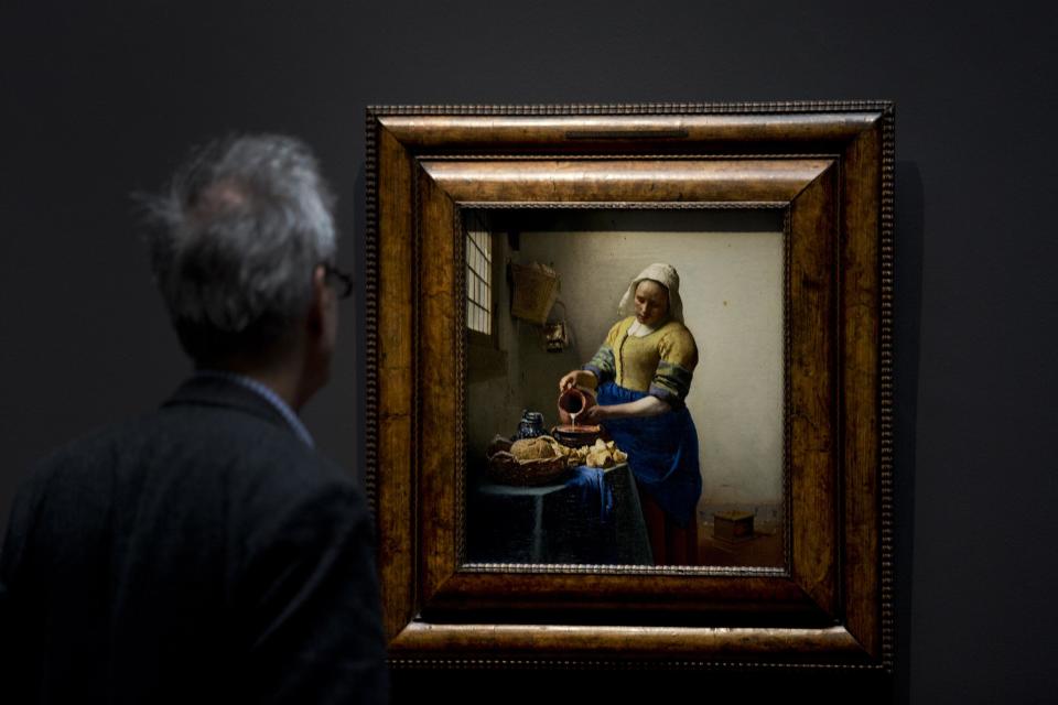 A man looks at Dutch master Johannes Vermeer's The Milkmaid painting (oil on canvas, circa 1660) during a press preview of the renovated Rijkmuseum in Amsterdam, Thursday April 4, 2013. The Rijksmusuem, home of Rembrandt's Night Watch and other national treasures, is preparing to reopen its doors on April 13, 2013 after a decade-long renovation. (AP Photo/Peter Dejong)