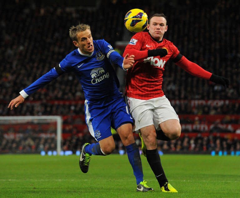 Everton's English defender Phil Neville (L) tangles with Manchester United's English striker Wayne Rooney (R) during the English Premier League football match between Manchester United and Everton at Old Trafford, Manchester, North West England, on February 10, 2013. United won 2-0