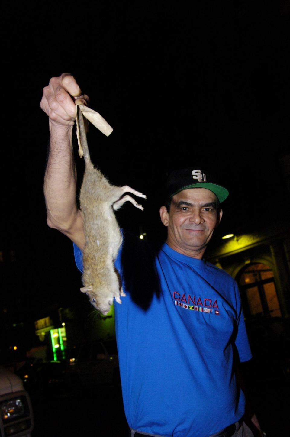 Manuel Rodriquez holds up a dead rat in 2004.