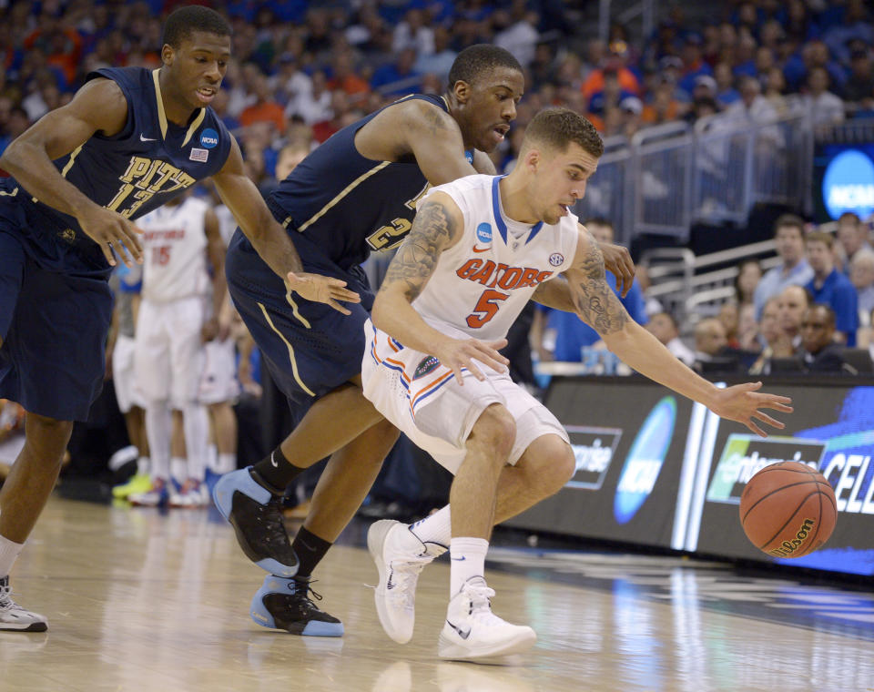 Florida guard Scottie Wilbekin (5) forces Pittsburgh forward Lamar Patterson (21) to turnover the ball as Pittsburgh guard Josh Newkirk (13) closes in during the second half in a third-round game in the NCAA college basketball tournament Saturday, March 22, 2014, in Orlando, Fla. (AP Photo/Phelan M. Ebenhack)