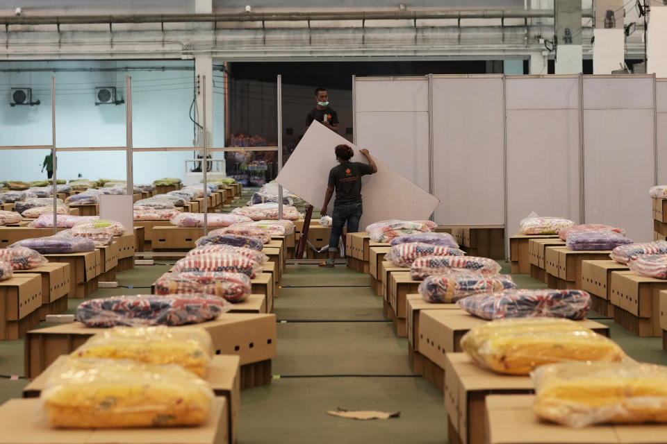 A worker installs partitions at field hospital set up inside a cargo building in Don Mueang International Airport in Bangkok, Thailand, Thursday, July 29, 2021. Health authorities raced on Thursday to set up yet another large field hospital in Thailand's capital as the country recorded a new high in COVID-19 cases and deaths. The hospital, one of many already in use, was being set up at one of Bangkok's two international airports after the capital ran out of hospital beds for thousands of infected residents. (AP Photo/Sakchai Lalit)