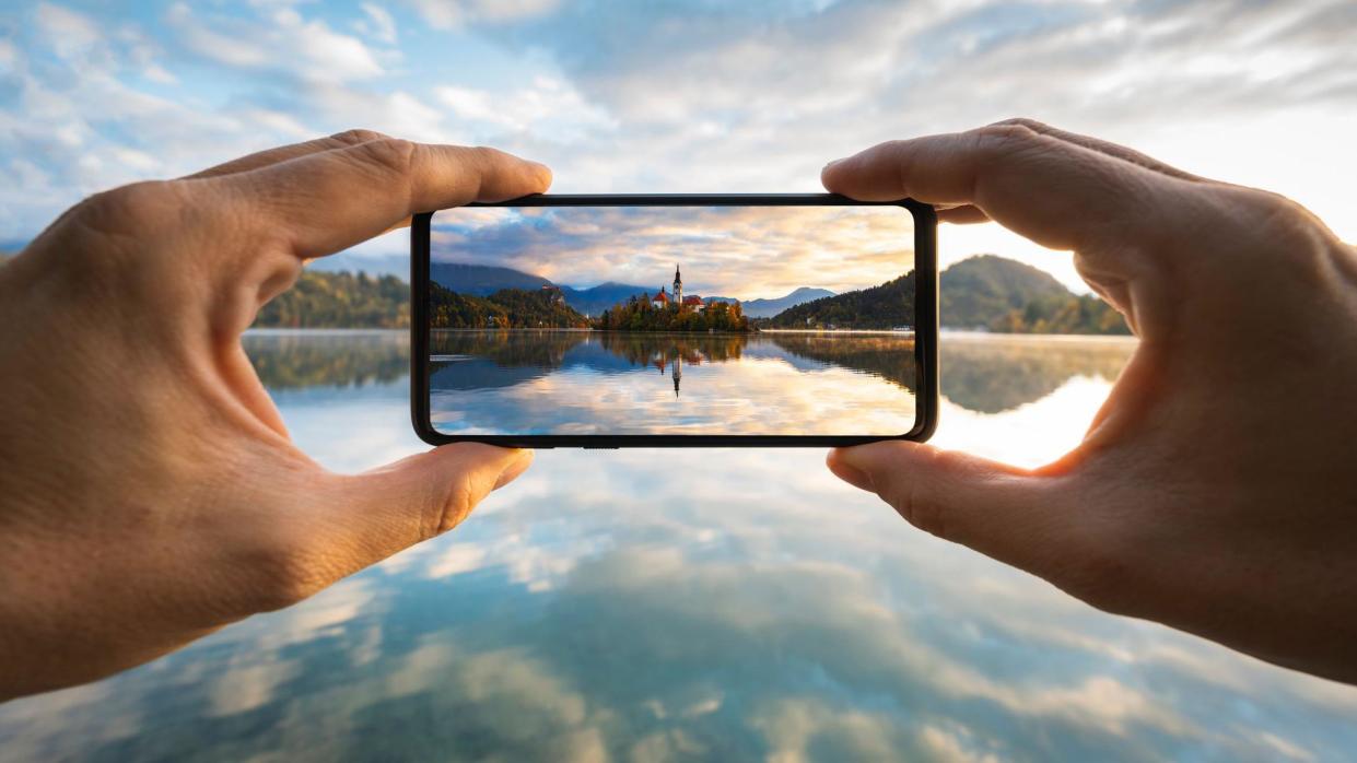 Hands holding a smartphone and taking a photo.