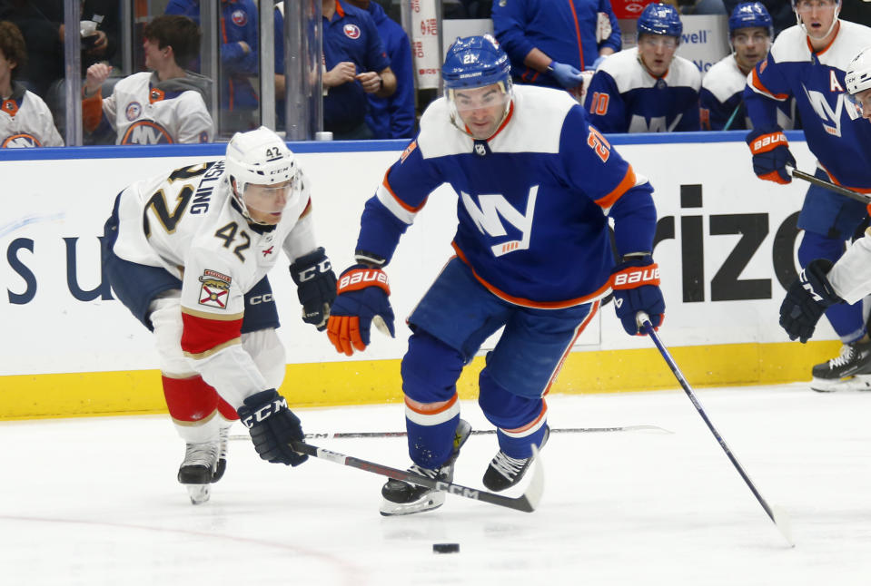 Florida Panthers defenseman Gustav Forsling (42) and New York Islanders center Kyle Palmieri (21) battle for the puck during the second period of an NHL hockey game, Saturday, Jan. 27, 2024, in Elmont, N.Y. (AP Photo/John Munson)