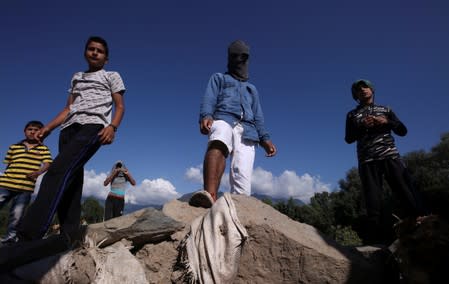 Kashmiri protesters stand at a barricade to block the entrance of a neighbourhood, during restrictions after the scrapping of the special constitutional status for Kashmir by the government, in Srinagar