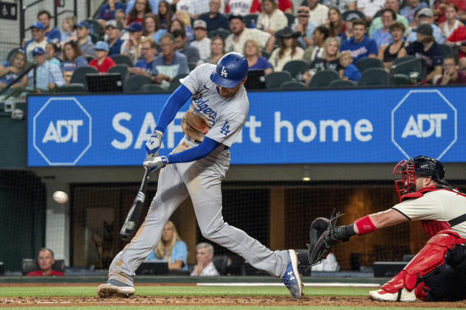 Los Angeles Dodgers' Freddie Freeman, left, connects for a two-run home run off Texas Rangers relief pitcher Glenn Otto during the fourth inning of a baseball game Saturday, July 22, 2023, in Arlington, Texas. Miguel Rojas also scored on the play. (AP Photo/Jeffrey McWhorter)