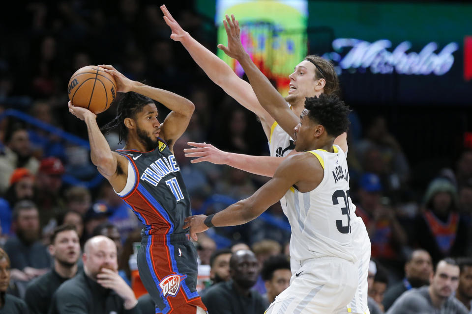 Oklahoma City Thunder guard Isaiah Joe, left, keeps the ball away from Utah Jazz guard Ochai Agbaji, front right, and forward Kelly Olynyk, back right, during the second half of an NBA basketball game Friday, March, 3, 2023, in Oklahoma City. (AP Photo/Nate Billings)