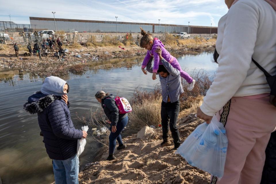 Immigrant families prepare to wade across the Rio Grande into El Paso, Texas on 30 January 2024 from Ciudad Juarez, Mexico (Getty Images)