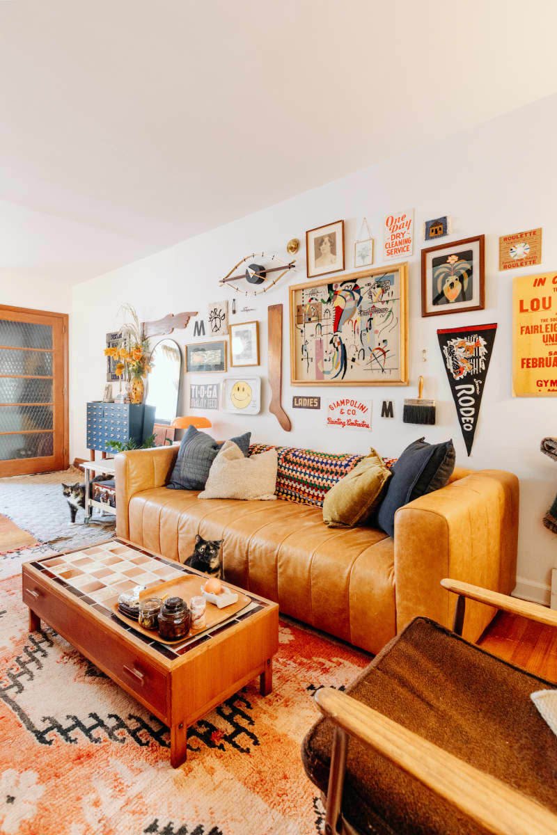 White living room is decorated with rust, orange, and red furniture and accessories.