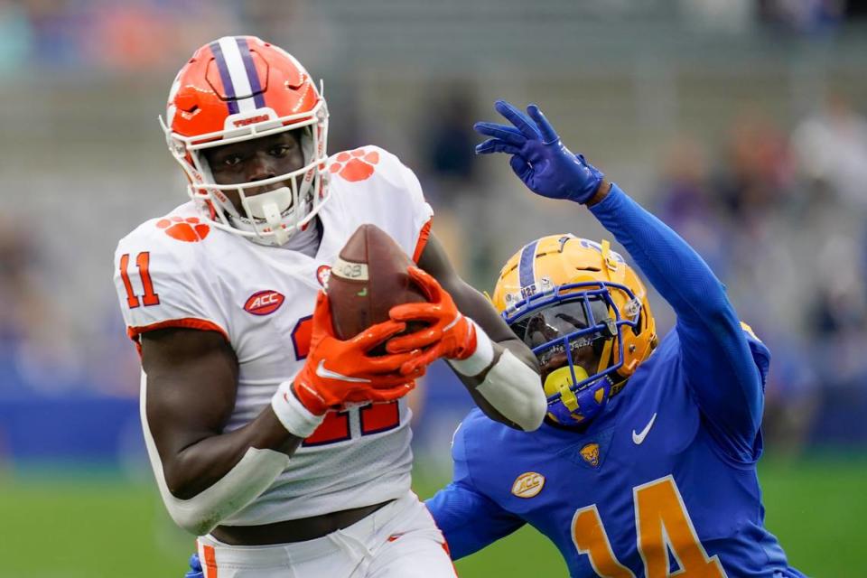 Clemson wide receiver Ajou Ajou (11) makes a catch past Pittsburgh defensive back Marquis Williams (14) during the first half of an NCAA college football game, Saturday, Oct. 23, 2021, in Pittsburgh. (AP Photo/Keith Srakocic)