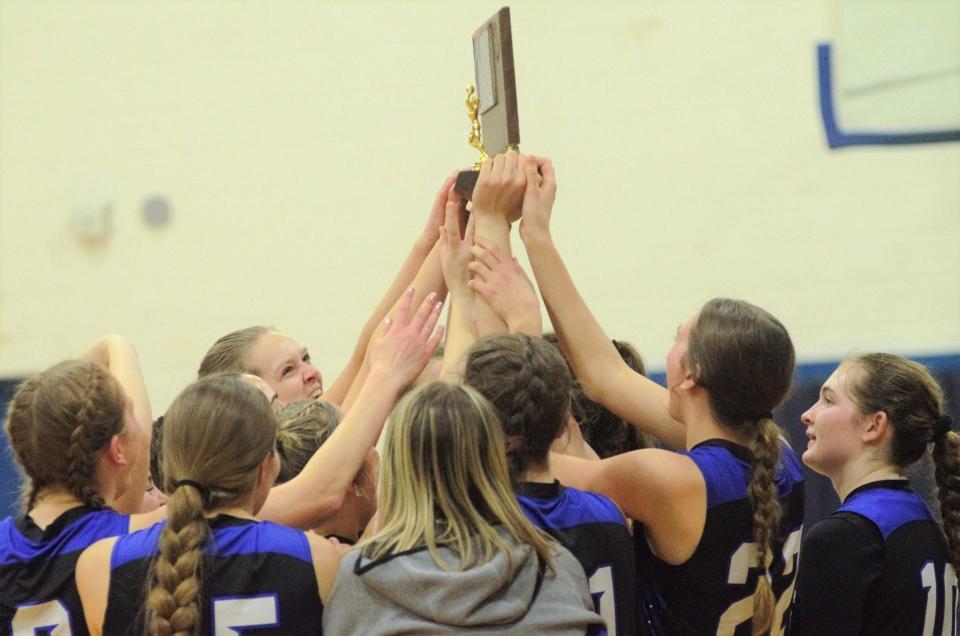 The Inland Lakes girls basketball team holds up the Ski Valley championship trophy after clinching the outright title with a road win over Gaylord St. Mary on Tuesday.