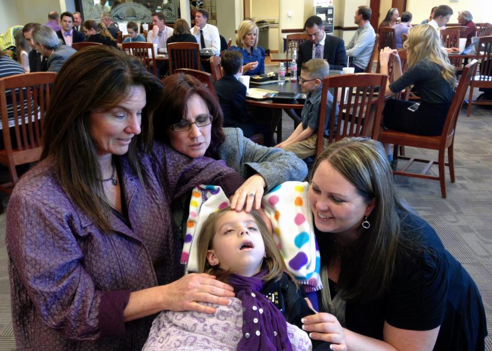 From left, Laura Warburton, Annette Maughan and Jennifer May surround Charlee Nelson in the Capitol cafeteria shortly after the House voted to pass Charlee’s Law and shortly before Charlee dozed off in Salt Lake City on March 13, 2014. Warburton was a lobbyist helping Maughan, May and Charlee’s mother Catrina to get Charlee’s Law passed. | Courtesy of Catrina Nelson