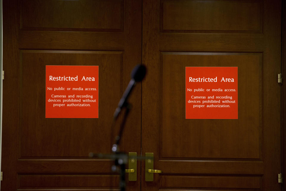 FILE - A microphone stands at the entrance to the House SCIF, the Sensitive Compartmented Information Facility, located three levels beneath the Capitol where witnesses and lawmakers hold closed interviews in the impeachment inquiry on President Donald Trump's efforts to press Ukraine to investigate his political rivals, in Washington, Nov. 15, 2019. When members of Congress want to peruse classified materials, they descend deep into the basement of the Capitol to a sensitive compartmented information facility, known as a SCIF. (AP Photo/Jose Luis Magana, File)