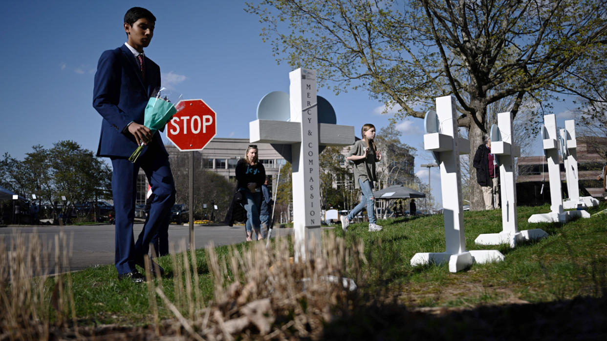 People pay their respects at a makeshift memorial in Nashville for victims of the Covenant School shooting.