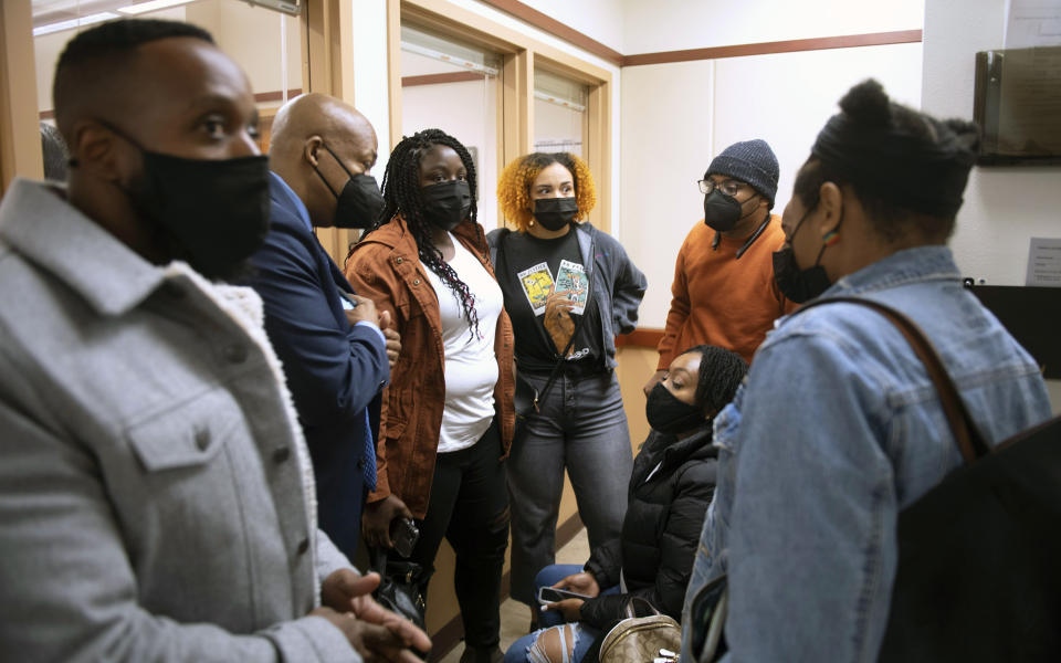 The family of Manuel Ellis gathers with attorney James Bible, second from left, following the arraignment of three Tacoma police officers charged in the death of Manuel Ellis, Friday, May 28, 2021 in Tacoma, Wash. Three Washington state police officers pleaded not guilty Friday in the death of Manuel Ellis, another Black man who pleaded for breath under an officer's knee. (Tony Overman/The News Tribune via AP, Pool)