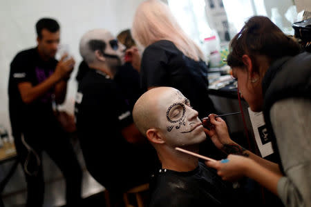 A man gets a make-up before taking part in a procession to commemorate Day of the Dead in Mexico City, Mexico, October 28, 2017. REUTERS/Edgard Garrido