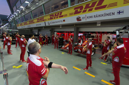 Ferrari Formula One pit crew warm up before they practise changing tyres ahead of the Singapore F1 Grand Prix Night Race in Singapore, September 15, 2016. REUTERS/Jeremy Lee