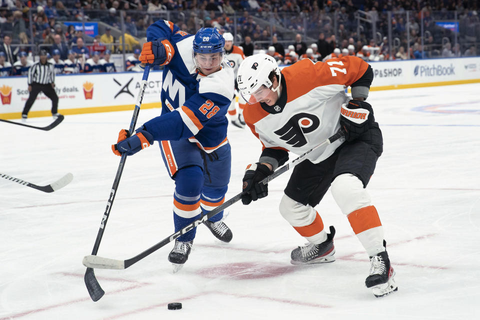 Philadelphia Flyers right wing Tyson Foerster (71) fights for the puck against New York Islanders defenseman Alexander Romanov (28) during the first period of an NHL hockey game Saturday, Nov. 25, 2023, in Elmont, N.Y. (AP Photo/Eduardo Munoz Alvarez)
