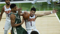 Milwaukee Bucks forward Giannis Antetokounmpo (34) and Phoenix Suns guard Devin Booker (1) battle for a loose ball during the second half of Game 3 of basketball's NBA Finals in Milwaukee, Sunday, July 11, 2021. (AP Photo/Paul Sancya)