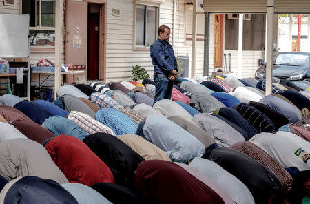 Australian journalist Dean Yates stands as Muslims pray at the Elsedeaq Heidelberg Mosque, located in the Melbourne suburb of Heidelberg in Australia, March 2, 2018. Picture taken March 2, 2018. REUTERS/Luis Enrique Ascui