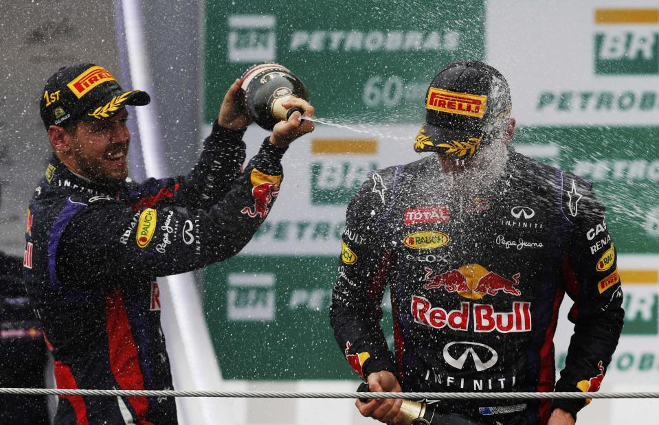 Mark Webber of Australia is sprayed with champagne by Sebastian Vettel of Germany and Fernando Alonso of Spain during podium celebrations after the Brazilian F1 Grand Prix at the Interlagos circuit in Sao Paulo