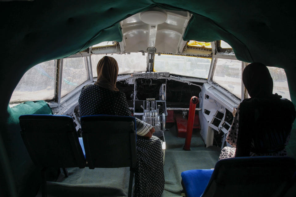 Palestinians visit the cockpit of a Boeing 707 after the plane was converted to a cafe restaurant, in Wadi Al-Badhan, near the West Bank city of Nablus, Wednesday, Aug. 11, 2021. The Palestinian territory has no civilian airport and those who can afford a plane ticket must catch their flights in neighboring Jordan. After a quarter century of effort, twins brothers, Khamis al-Sairafi and Ata, opened the “Palestinian-Jordanian Airline Restaurant and Coffee Shop al-Sairafi” on July 21, 2021, offering people an old airplane for customers to board. (AP Photo/Majdi Mohammed)