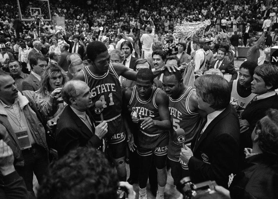 CBS announcer Billy Packer, left, interviews N.C. State seniors Thurl Bailey, Dereck Whittenburg, and Sidney Lowe after the Wolfpack won the National Championship on April 4, 1983.