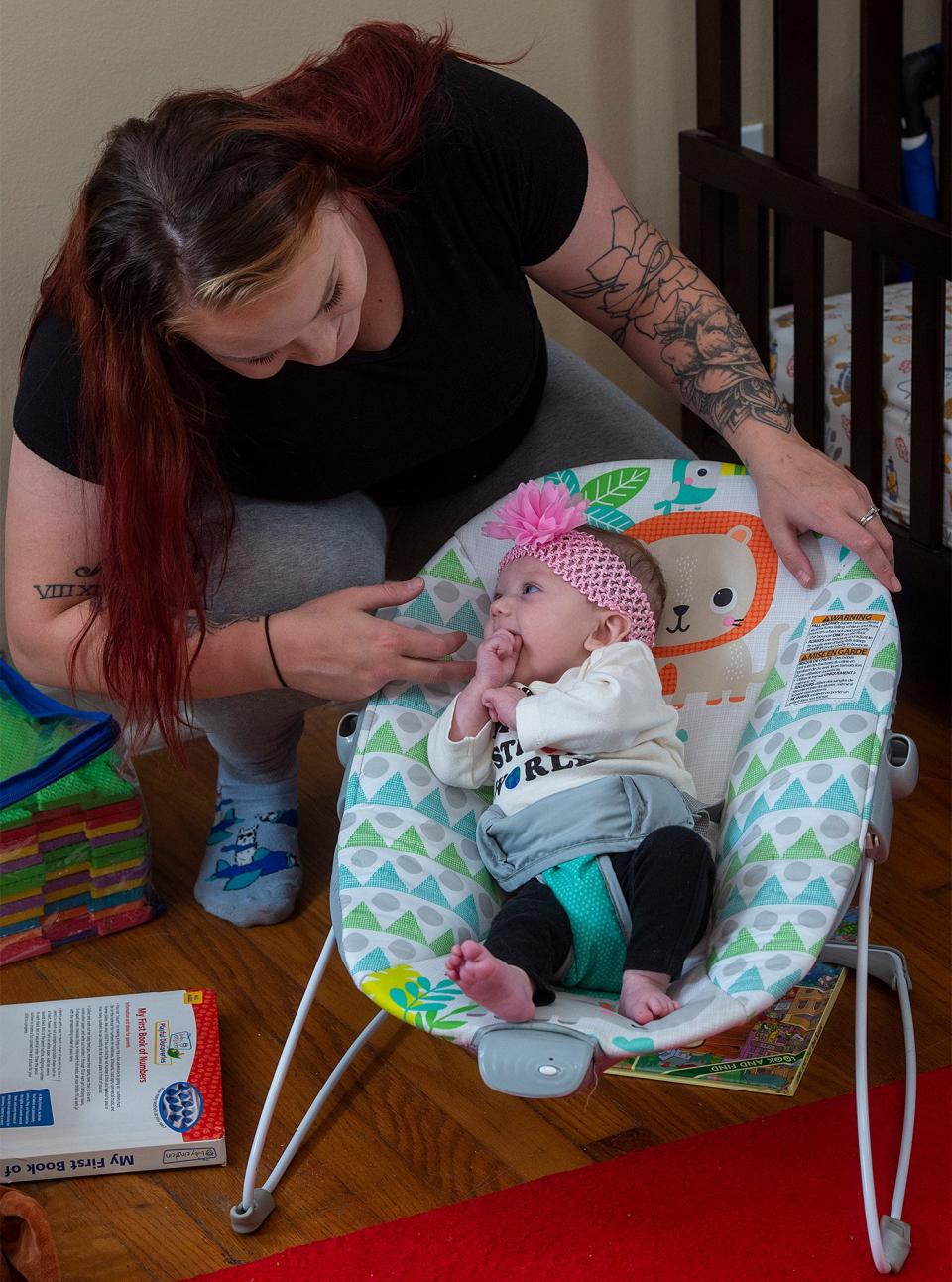 Patricia, tends to her daughter, Annalyce, 3 months, inside their home in Bristol Township, on Friday Nov. 18, 2022.