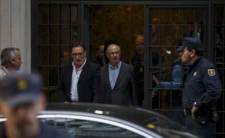 Rodrigo Rato (C), former People's Party minister and former managing director of the International Monetary Fund, is lead by police as they leave his residence after an inspection in Madrid, April 16, 2015. REUTERS/Sergio Perez