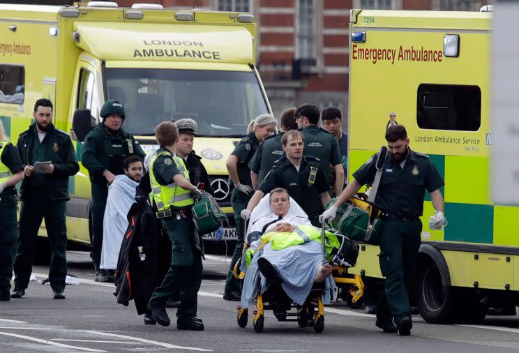 Emergency services staff provide medical attention close to the Houses of Parliament in London (AP Photo/Matt Dunham)