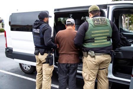 U.S. Immigration and Customs Enforcement officers make an arrest after carrying out a raid in San Francisco