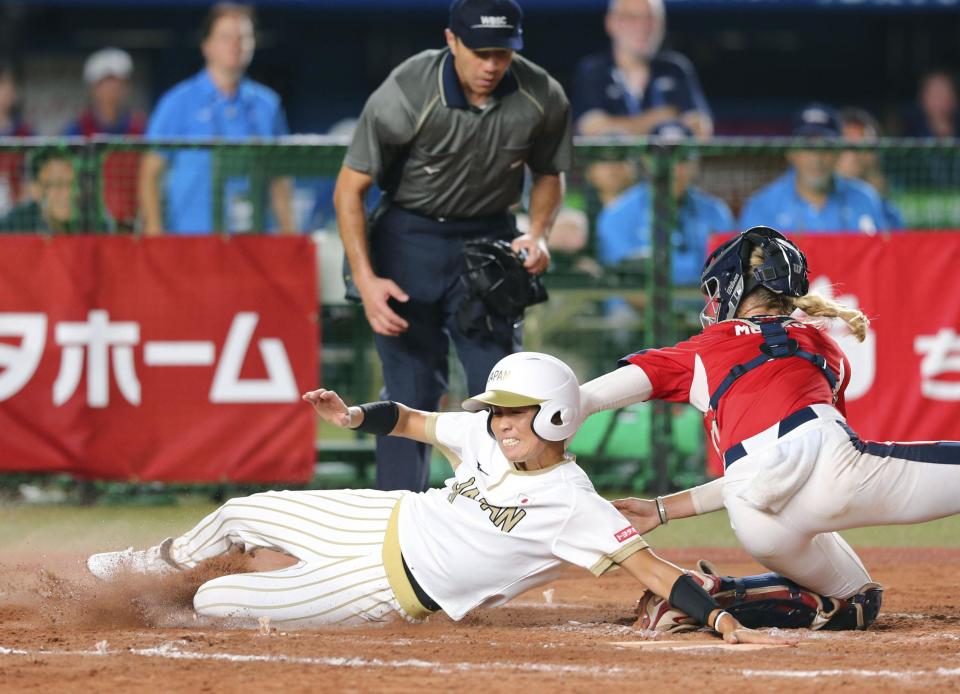 Japan's Misato Kawano, in white jersey, is tagged out at home by United States' catcher Aubree Munro, right, during Women's Softball World Championship game Saturday Aug. 11, 2018 in Makuhari, east of Tokyo. United States to a 4-3 win over Japan and into the final of the women's world softball championship. (Kyodo News via AP)