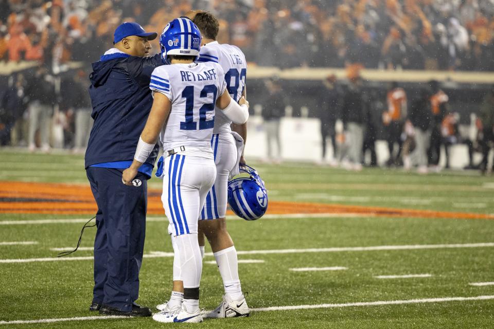 BYU coach Kalani Sitake talks with quarterback Jake Retzlaff (12) and tight end Isaac Rex (83) after the team’s NCAA college football game against Oklahoma State on Saturday, Nov. 25, 2023, in Stillwater, Okla. | Mitch Alcala, Associated Press