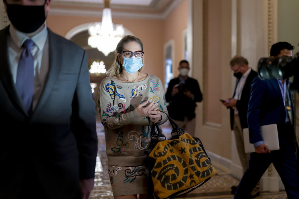 FILE - Sen. Kyrsten Sinema, D-Ariz., walks to the chamber after a Senate Democratic Caucus meeting at the Capitol in Washington, Nov. 2, 2021. Twenty years ago, a Green Party activist running for city council in Phoenix named Kyrsten Sinema likened the practice of raising campaign cash to “bribery.” Now a first-term Arizona senator, she no longer has such qualms, raising nearly $500,000 in donations from financial and pharmaceutical sector this year. (AP Photo/J. Scott Applewhite, File)