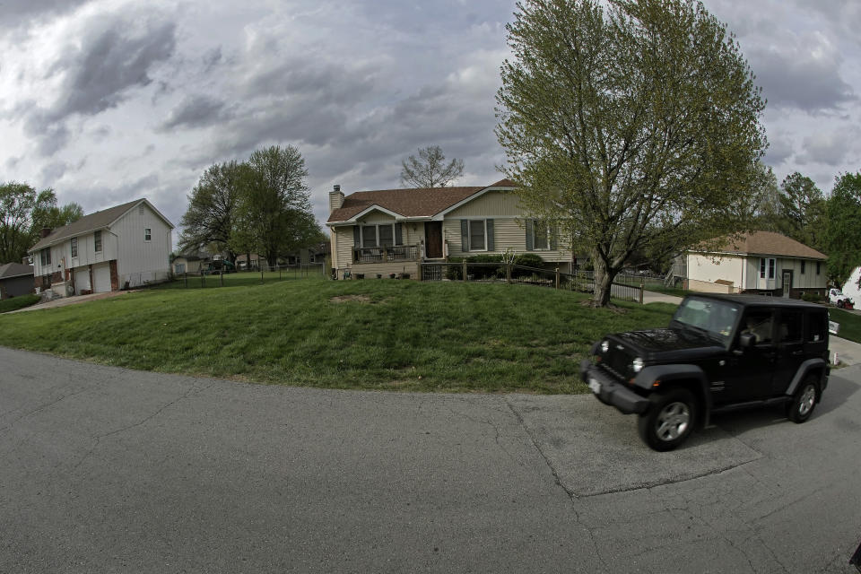 A motorist drives past the house, Wednesday, April 19, 2023, where 84-year-old Andrew Lester shot 16-year-old Ralph Yarl a week earlier in Kansas City, Mo. (AP Photo/Charlie Riedel)