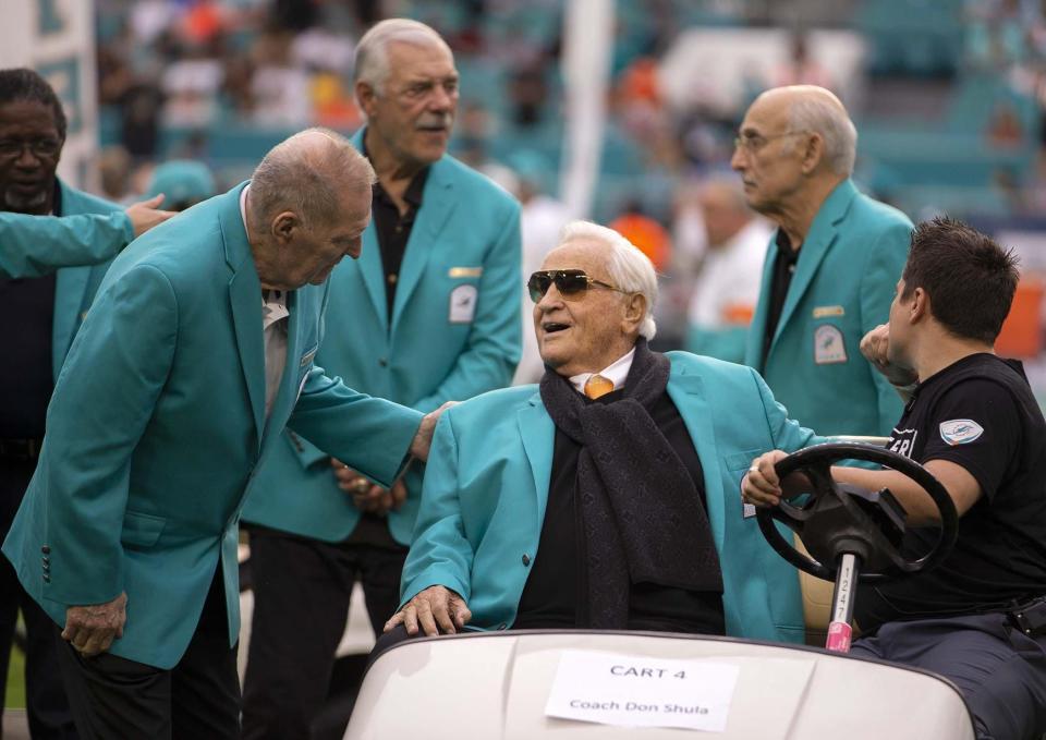 Coach Don Shula talks with Jim Kiick (left) with Larry Csonka and Manny Fernandez in the background. The Miami Dolphins 1972 team celebrated being named the best NFL team ever during a halftime ceremony at Hard Rock Stadium in Miami Gardens, Dec. 22, 2019.