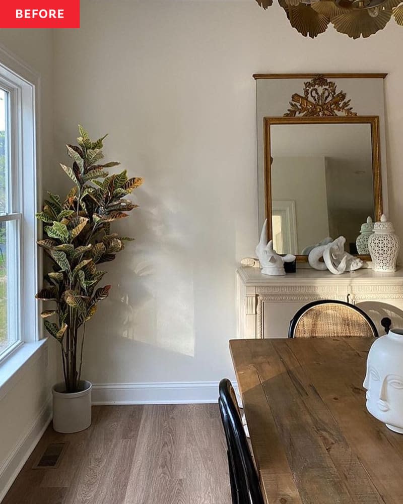 A white dining room with a plant in the corner