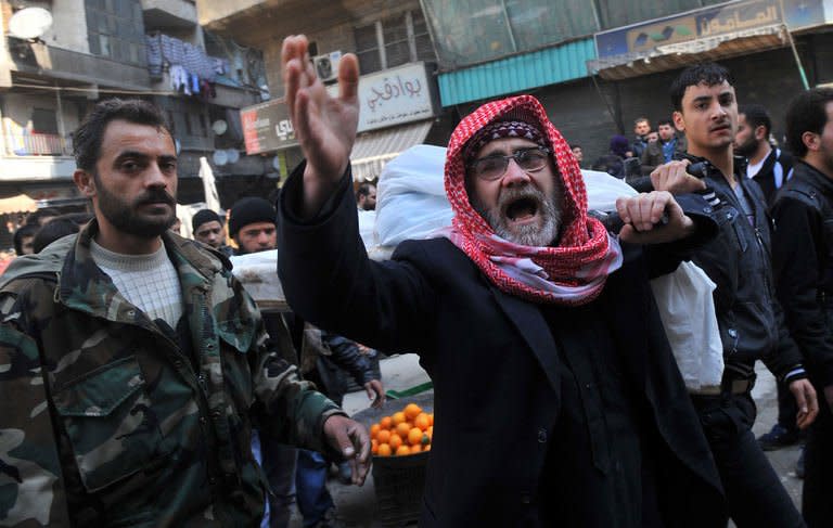 Syrians carry the body of a fighter during a funeral after Friday prayer in the northeastern city of Aleppo on February 15, 2013